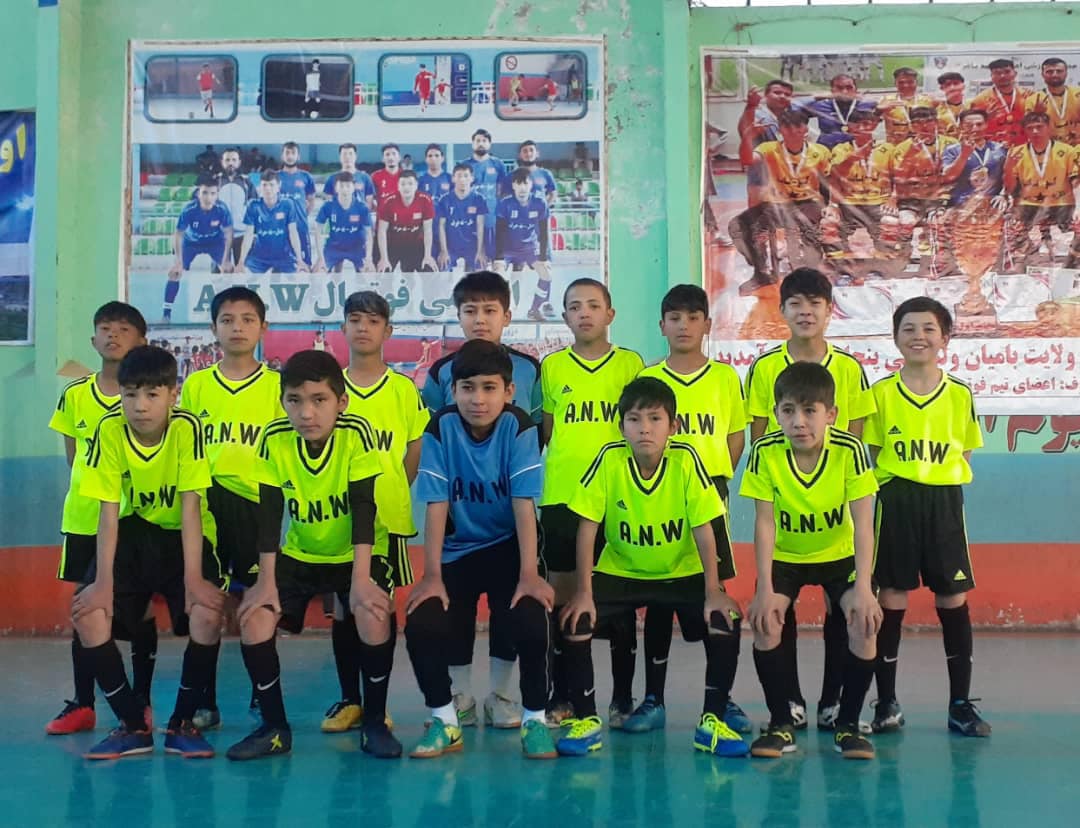 Children playing soccer indoors